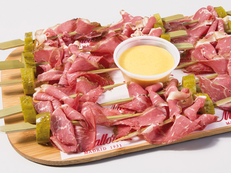 Bandeja de brochetas de pastrami. Acompañado de salsa de mostaza picante Bandeja de brochetas de pastrami. Acompañado de salsa de mostaza picante